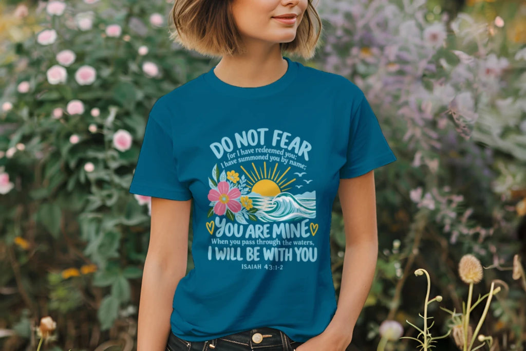 Woman wearing the Antique Sapphire Do Not Fear Isaiah 43:1-2 tee in a garden