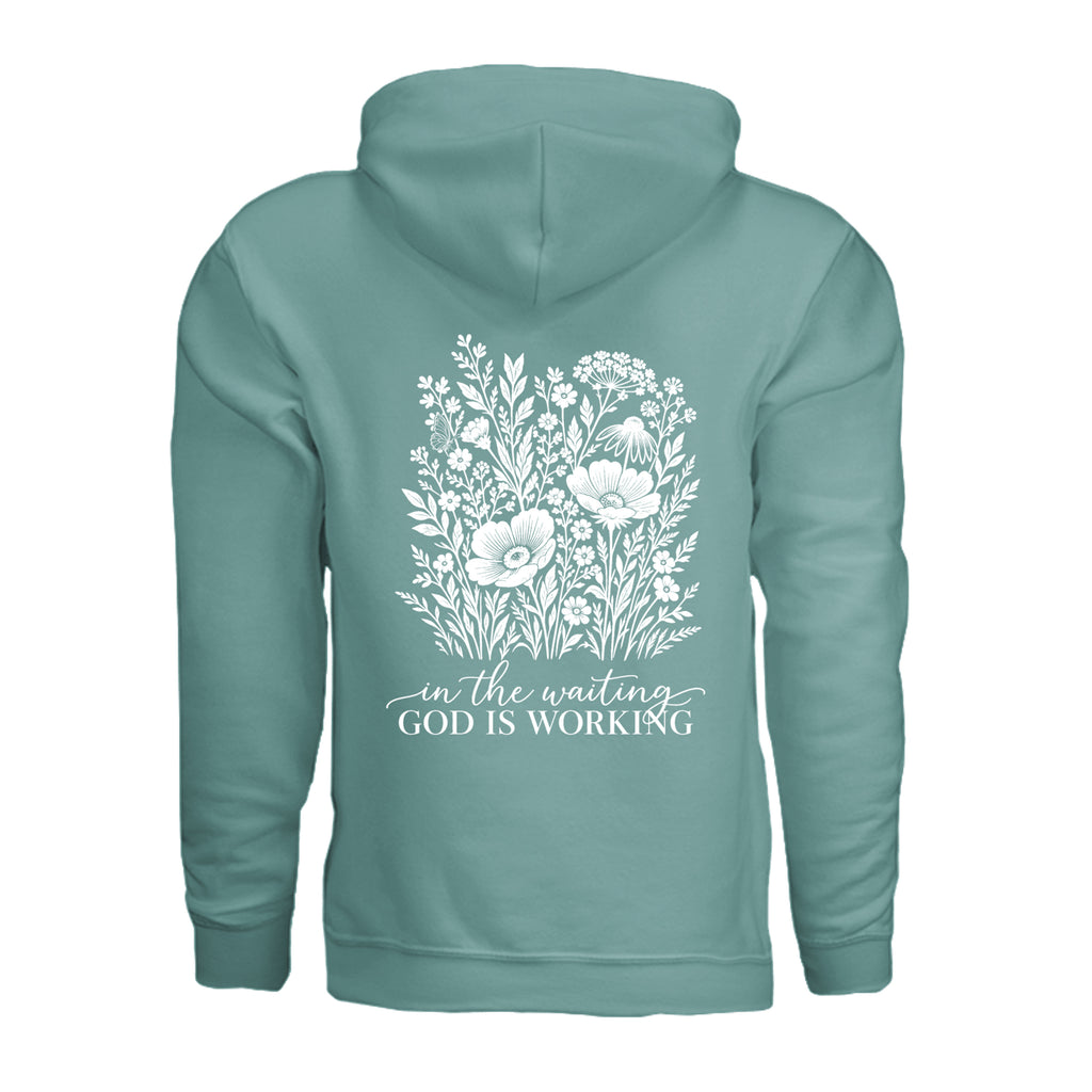 In the Waiting, God Is Working floral hoodie in Aquatic, back view with the full wildflower and message design
