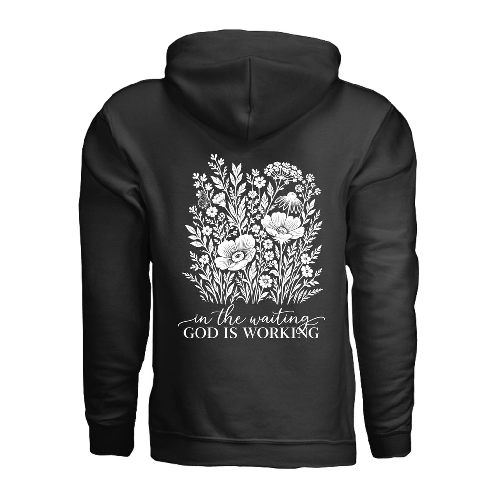 In the Waiting, God Is Working floral hoodie in Black, back view with the full wildflower and message design